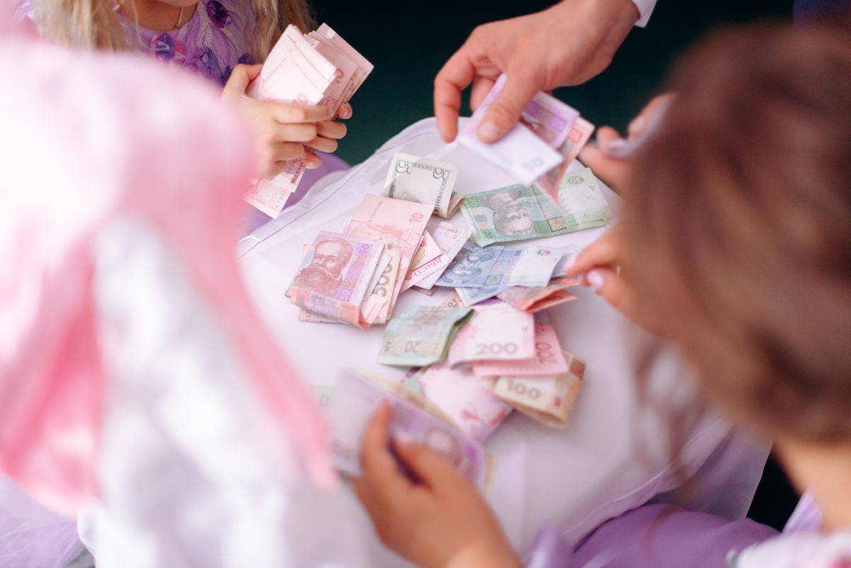 بچے اور بڑے کے ہاتھ کرنسی نوٹ گنتے ہوئے — سرکاری مالی امداد کی علامت