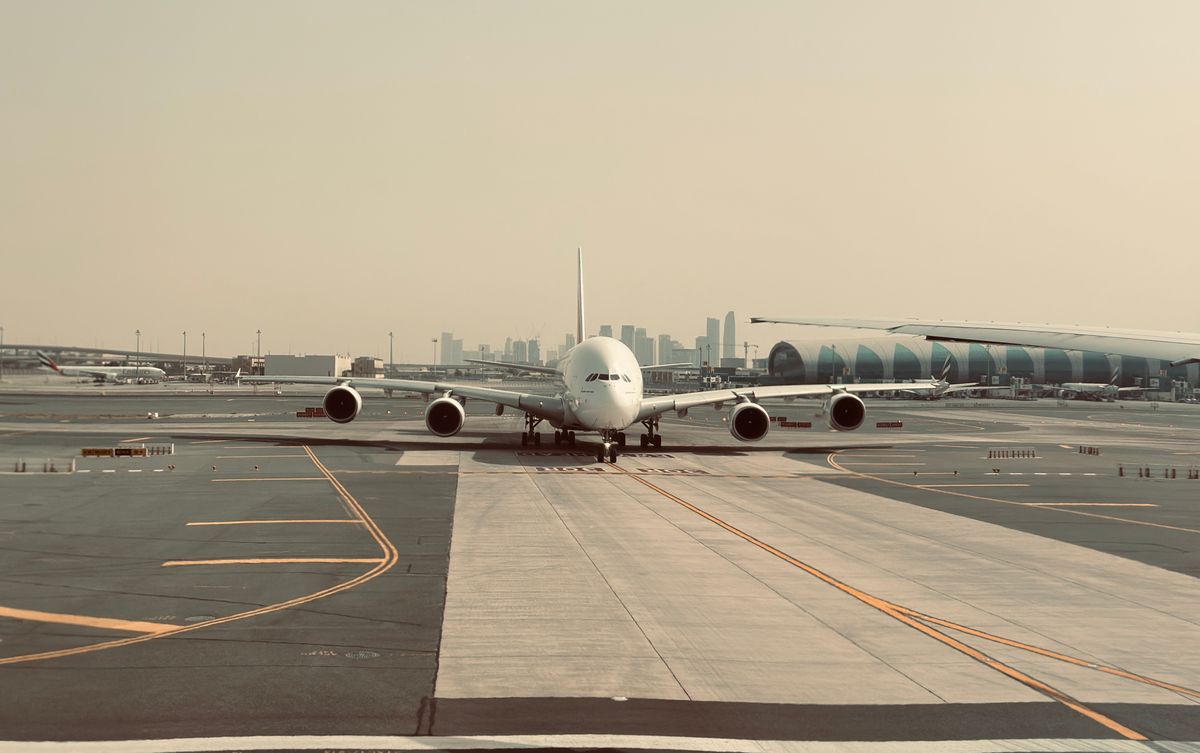 دبئی ایئرپورٹ پر طیارہ اور شہر کا منظر — دبئی UAE ویزا چیک