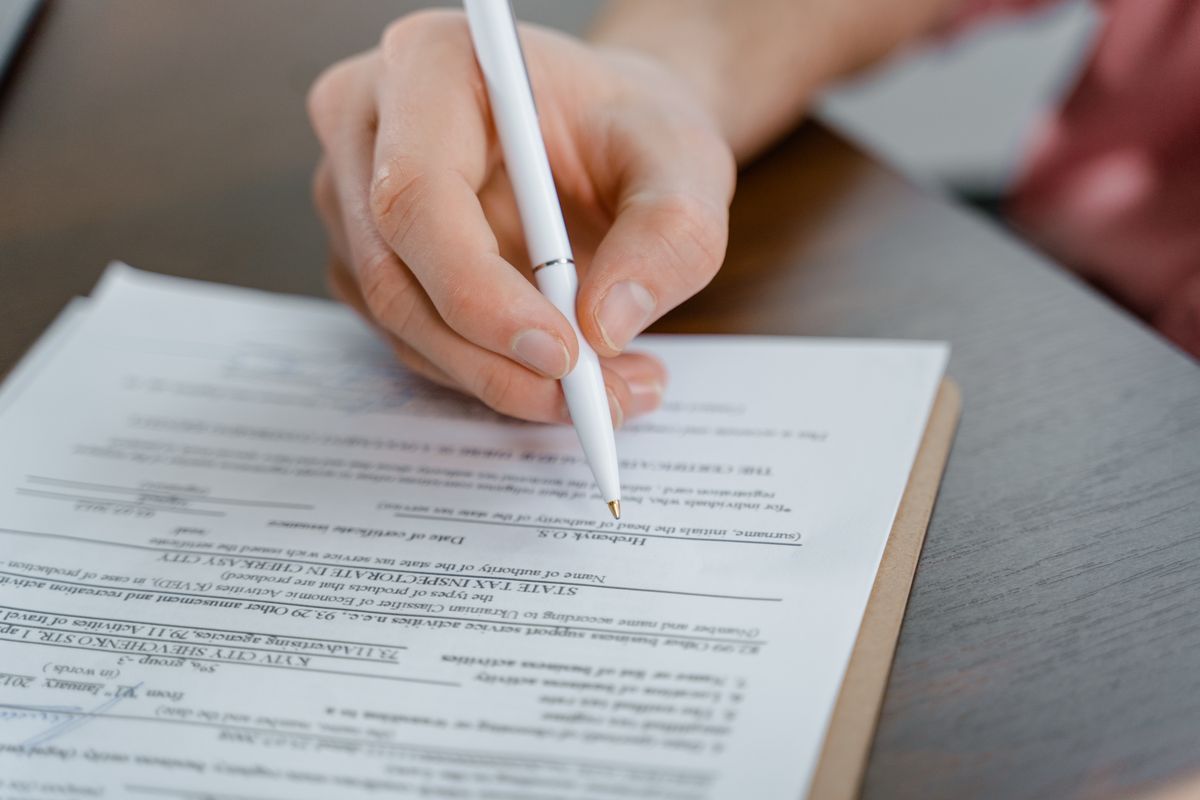 دستاویز پر دستخط کرتی قلم — ویزا کے لیے درکار کاغذات کی تیاری
